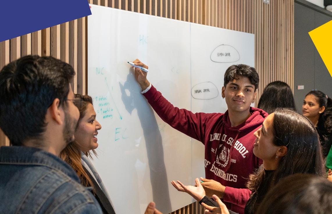 A group of students standing in front of a white board