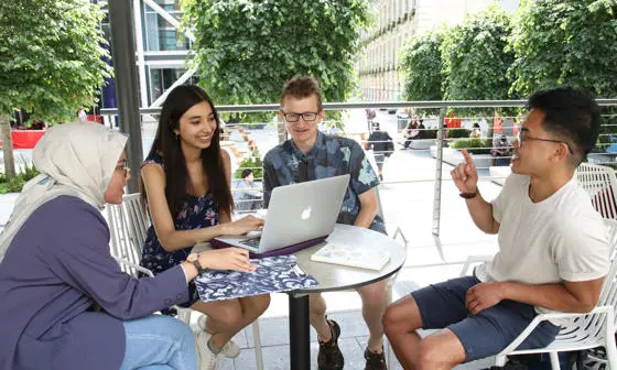 Research students around table on campus.