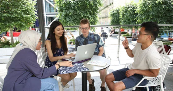 Research students around table on campus.
