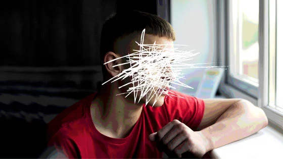 A photograph of a boy gazing out of the window with his face etched out