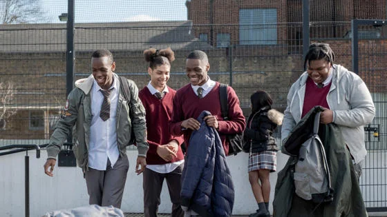 Young men in school uniform walking and smiling