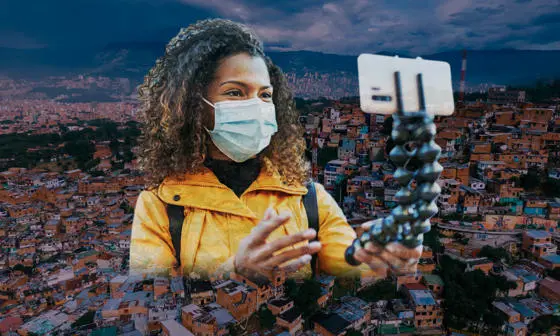 A woman with selfie stick and Medellín city behind her