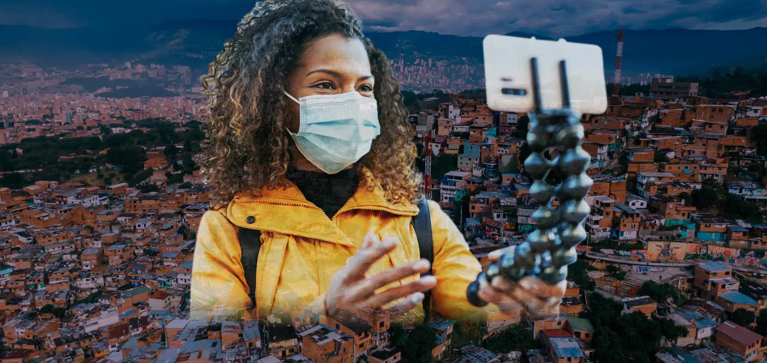 A woman with selfie stick and Medellín city behind her