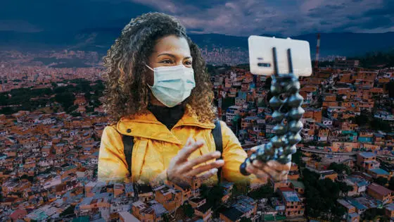 A woman with selfie stick and Medellín city behind her