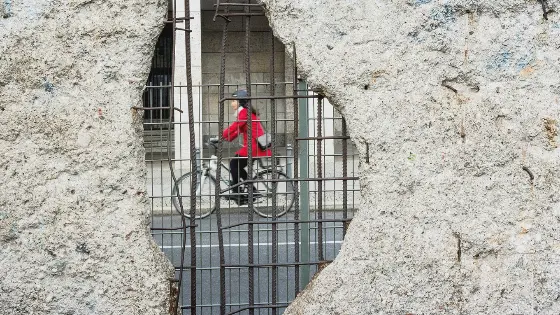 woman cycling seen through the Berlin wall