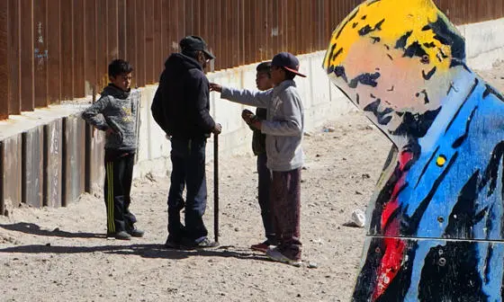Trump and migrants by a wall