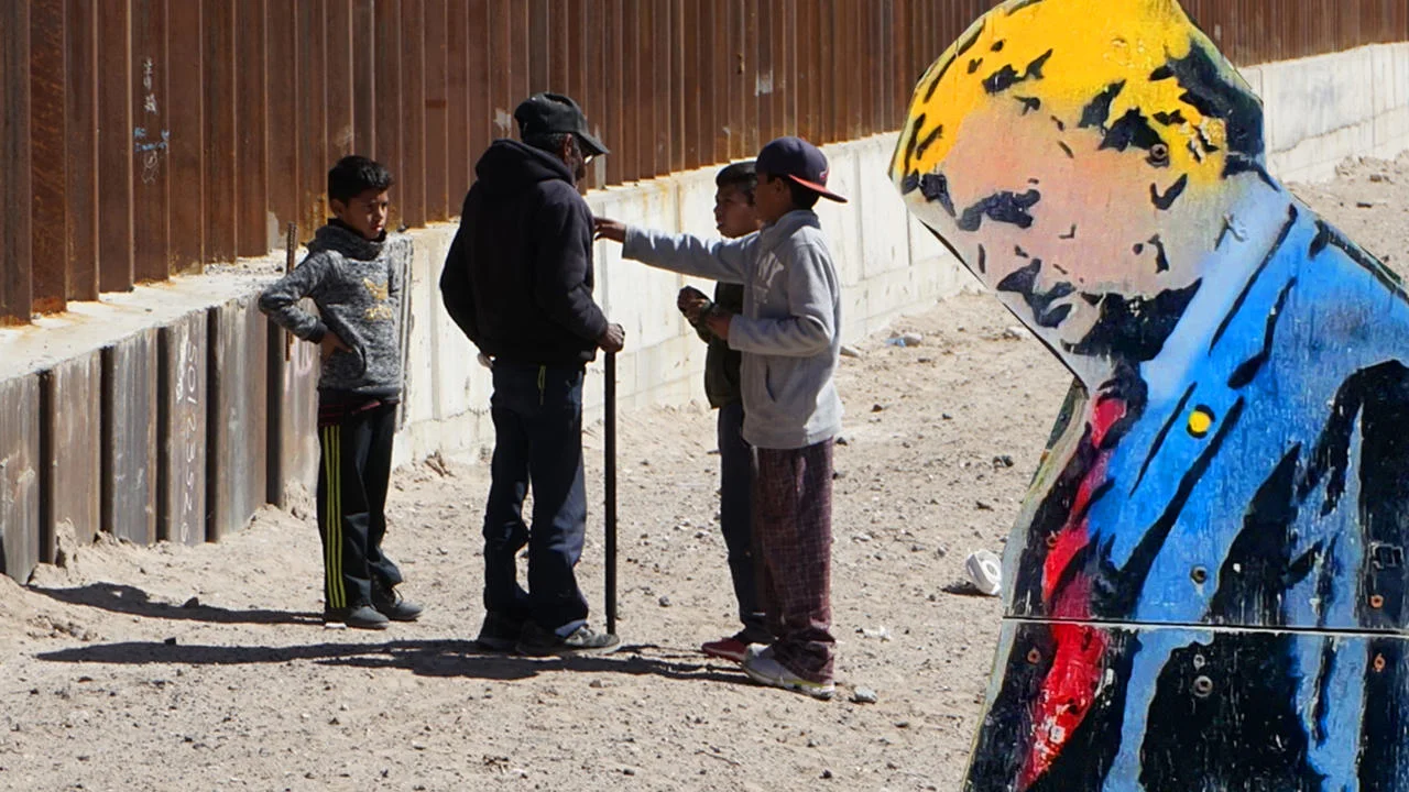 Trump and migrants by a wall