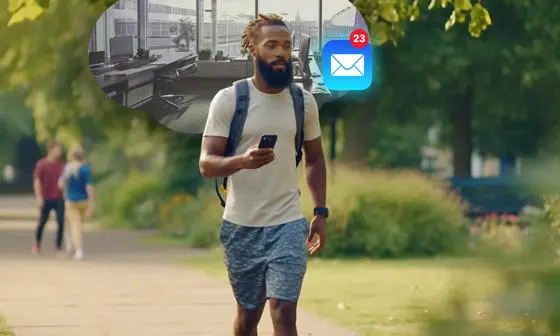 A man checking his work email on his phone while walking in a park