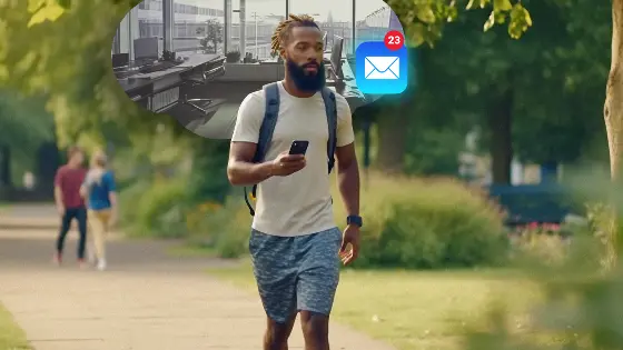 A man checking his work email on his phone while walking in a park