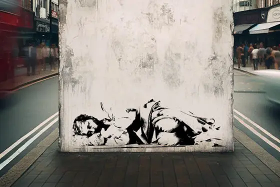 A Banksy-style graffiti of a homeless person on a wall in London