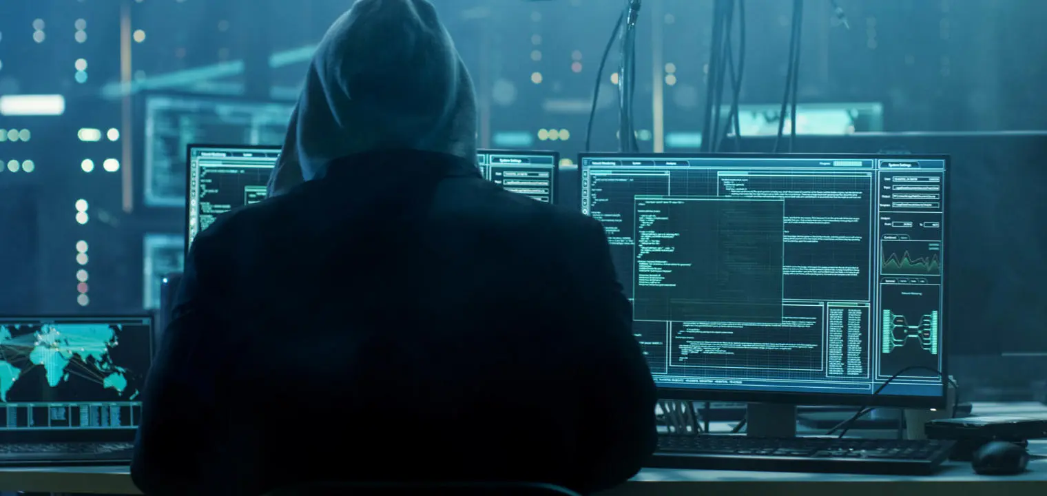 man sitting in front of computer screens