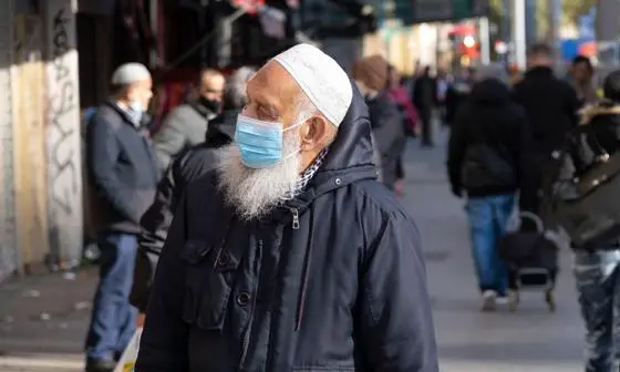 A man in a high street wearing a face mask