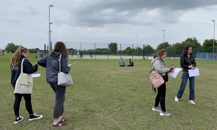 Three researchers-in-residence visiting a typical neighbourhood park in Crewe with basketball and football court and playground.