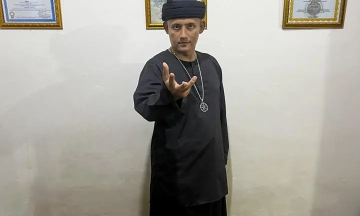 hpynosis practitioner standing by wall of certification