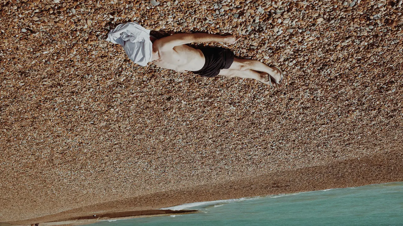 man lying on the beach sunbathing