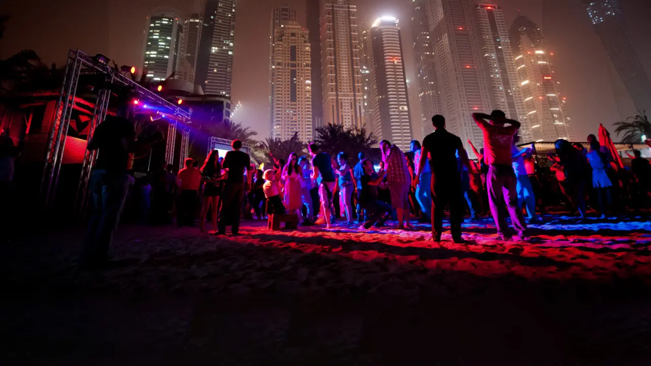People dancing at a nightclub under Dubai skyline