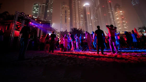 People dancing at a nightclub under Dubai skyline