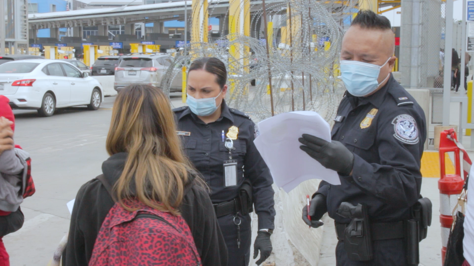 US Customs and Border Protection officials check the papers of a Honduran person