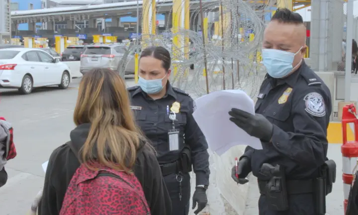 US Customs and Border Protection officials check the papers of a Honduran person