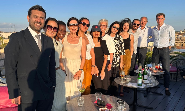 A group of alumni standing on a roof terrace. 