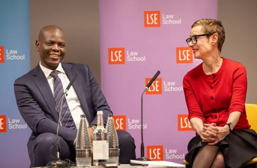 A man and woman sitting behind a microphone smiling