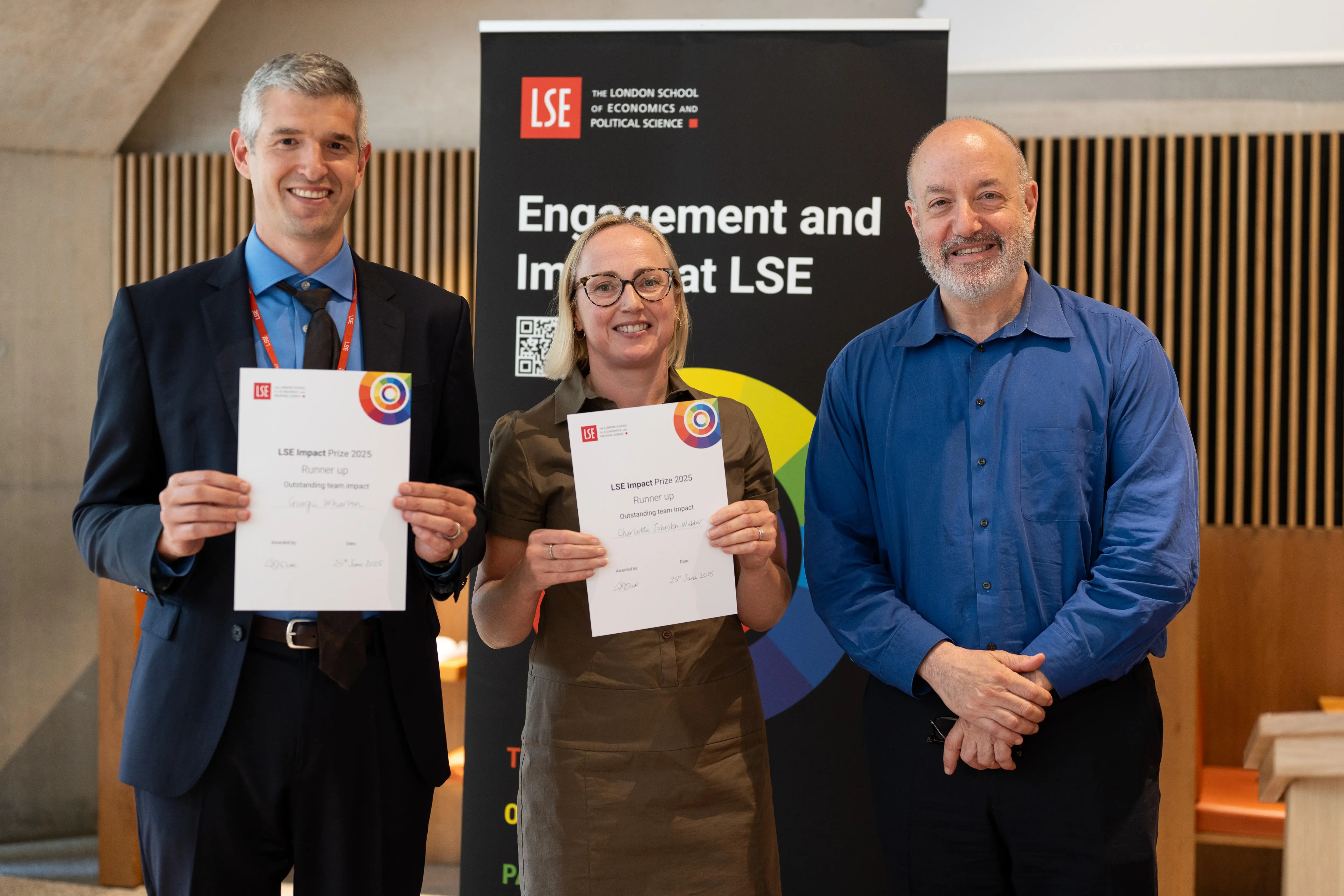 Photo of George Wharton and Dr Charlotte Johnston-Webber receiving certificates from Larry Kramer