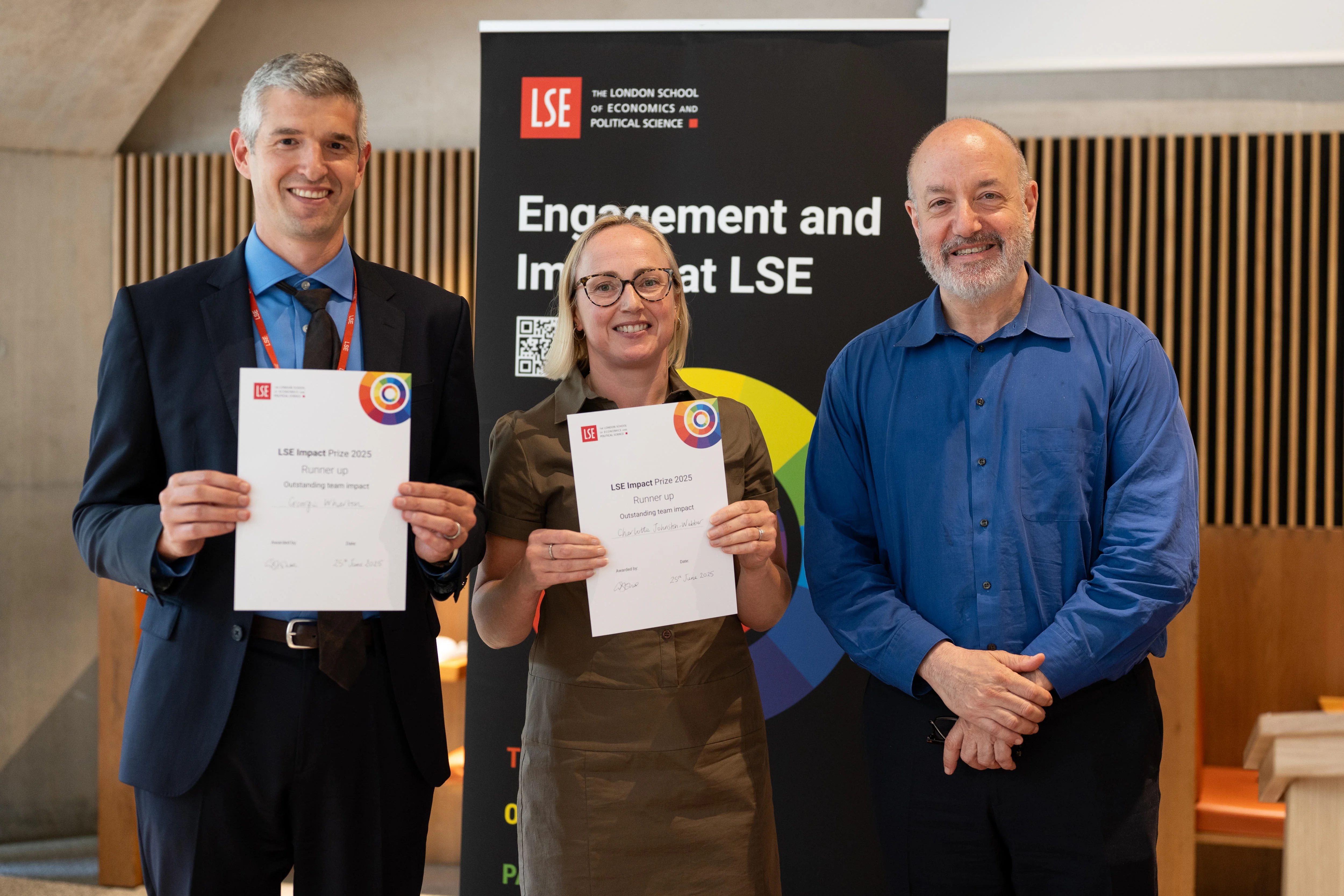 Photo of George Wharton and Dr Charlotte Johnston-Webber receiving certificates from Larry Kramer