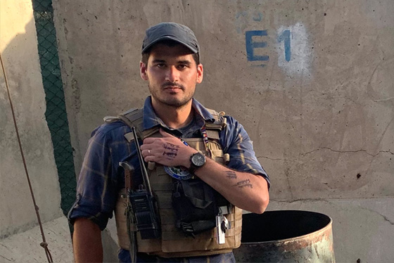 Sam Aronson stands in Afghanistan wearing his security vest, the names of those he is rescuing written on his arm