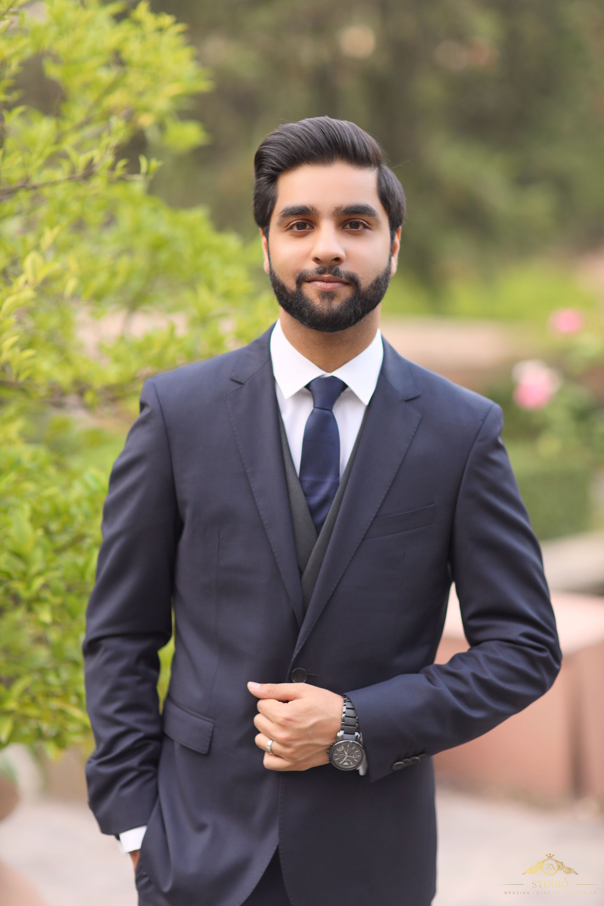 Sannan if facing the camera wearing a suit.