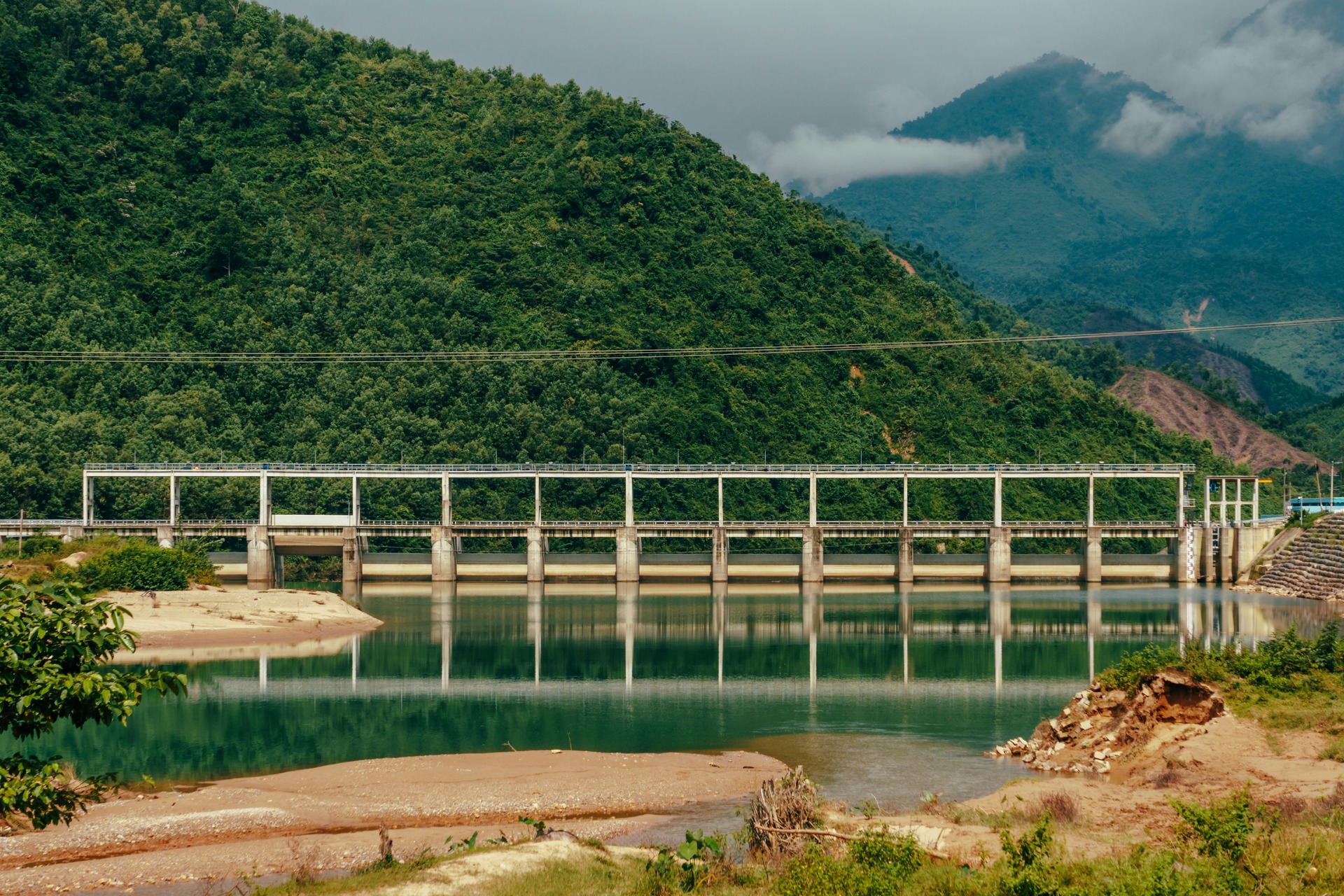 A bridge over the river with mountains in the background
