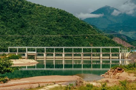 A bridge over the river with mountains in the background