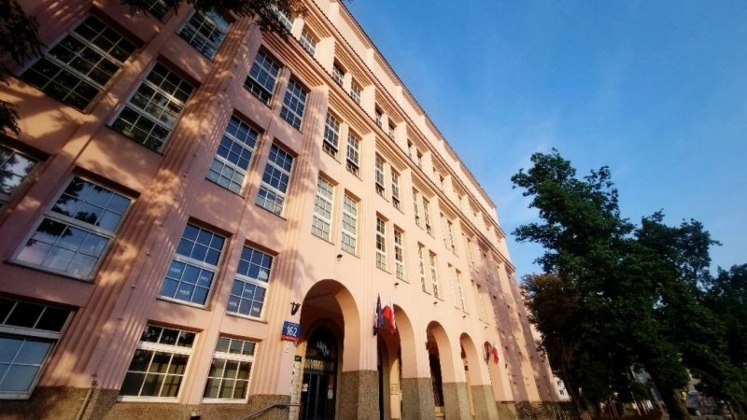 Grand university or academic building on SGH Warsaw Campus with classical architecture and arched entrances, viewed from street level.