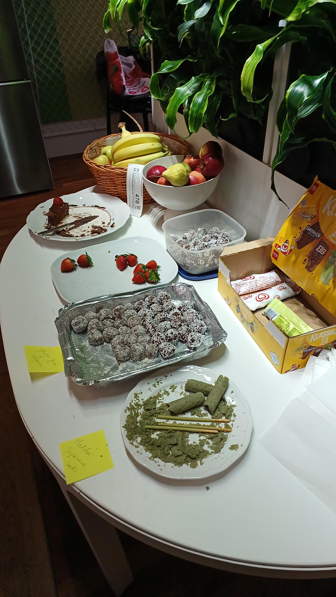 Differents foods on a table, including fruits, chocolate, and a matcha-flavoured cake.