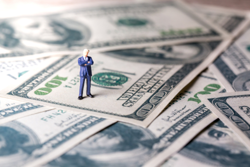 Figure on pile of dollars