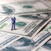 Figure on pile of dollars