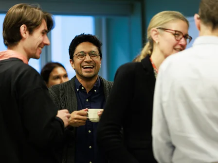 PhD student smiling with a cup of tea
