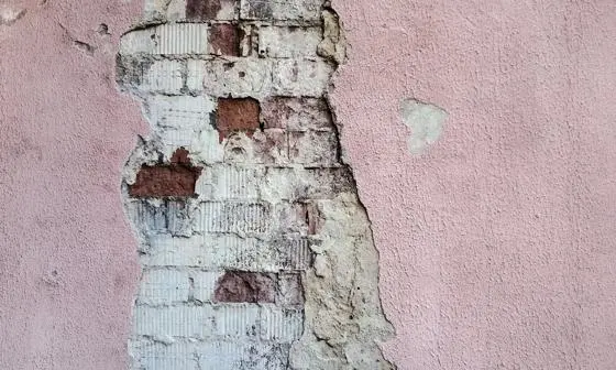 A wall with exposed brick