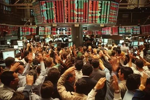 Crowd of traders on a trading floor, staring at electronic boards and gesticulating
