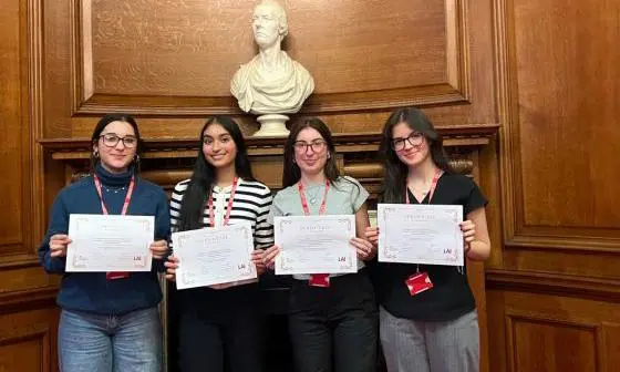 Group of students smile holding certificates