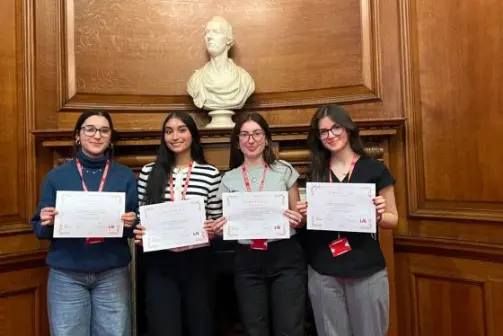 Group of students smile holding certificates