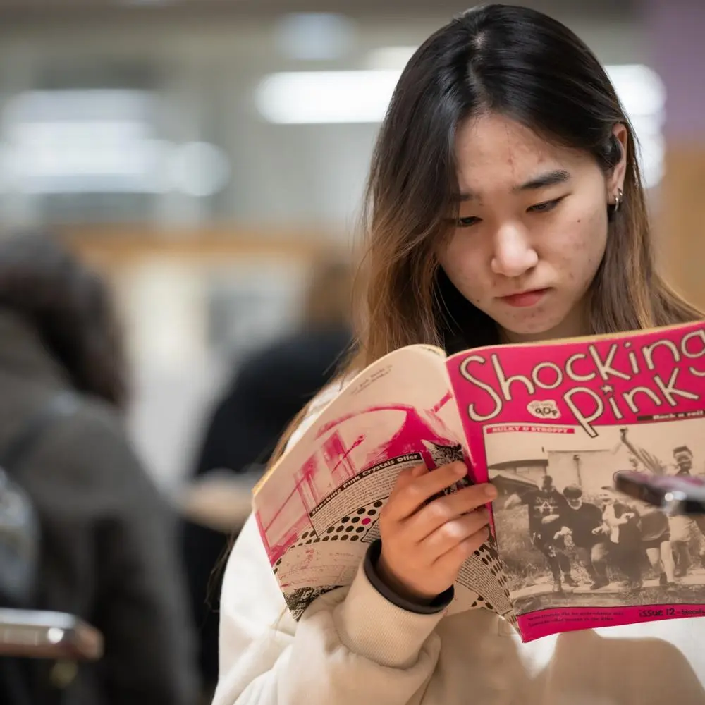 A person in the reading room looking at a magazine