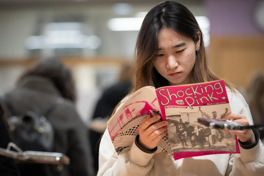 A person in the reading room looking at a magazine