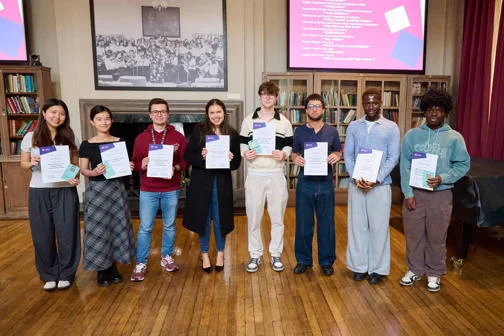 8 student staff winners stood posing together with their certificates.