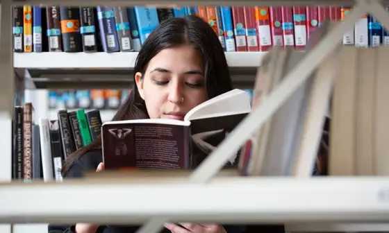 A student reading a book in the Library