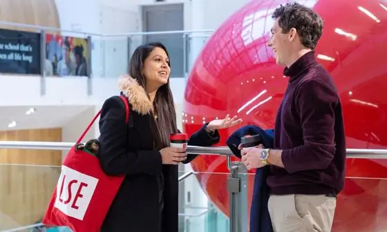 Students in the Cheng Kin Ku Building, with a red LSE tote bag and keepcup
