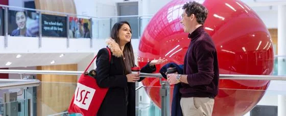 Students in the Cheng Kin Ku Building, with a red LSE tote bag and keepcup