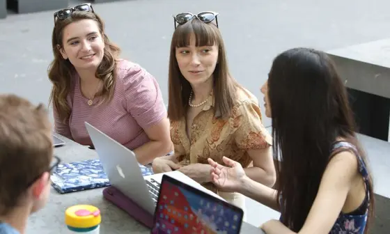 Student group sitting at a cafe with laptops