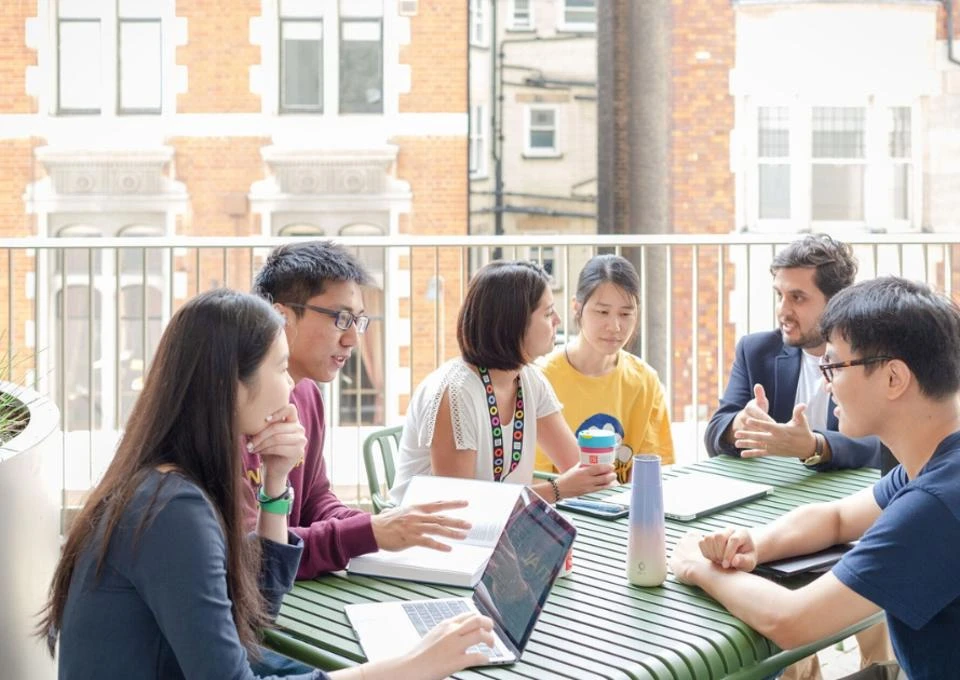 a group of students sitting around a table at LSE
