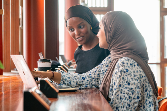Two students looking at a laptop