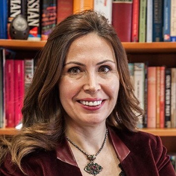 Woman smiling in front of a bookcase